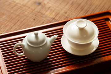 Porcelain cup and kettle on bamboo board