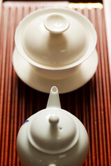 Porcelain cup and kettle on bamboo board