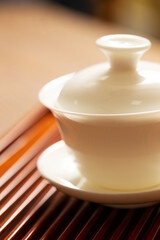 Porcelain green tea cup on bamboo board