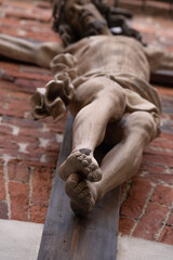 Crucifixion of Jesus Christ. An ancient statue. Selective focus on feet. Faith, religion, death, resurrection concept.