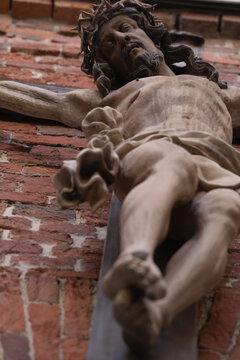 Crucifixion of Jesus Christ. Close up an ancient statue. Faith, religion, death, resurrection concept. Vertical image and selective focus on eyes.