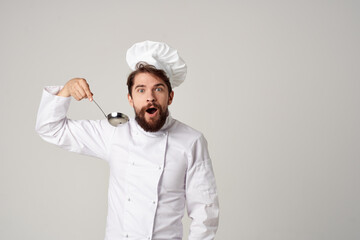 Cheerful chef with a ladle in his hands is trying food Gourmet restaurant