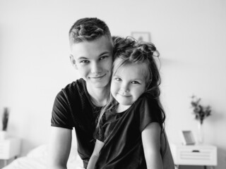 caucasian siblings - teenager boy brother and little girl sister in bedroom modern loft interior. Typical family lifestyle