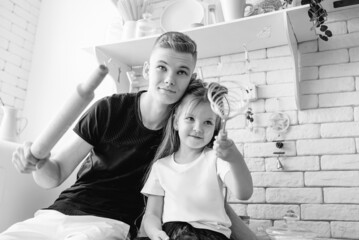 caucasian funny cute siblings in kitchen - little girl with older brother baking in kitchen. Bake,...
