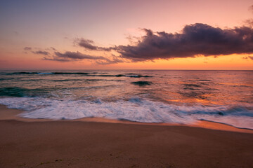 calm sea scenery at dawn. waves wash empty sandy beach at twilight. relax and summer vacation concept. warm velvet season weather with clouds on the sky