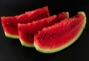 Three skibki ripe watermelon on a black background