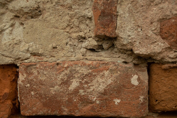 macro, orange brick wall covered with cement. Background, texture