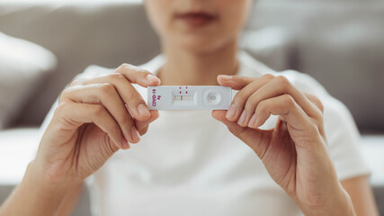 Woman self test for COVID-19 home test kit. asian woman showing result coronavirus rapid antigen home testing kit, Coronavirus nasal swab test for infection.