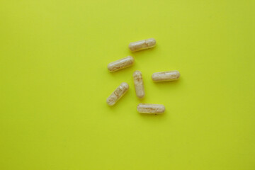 White tablets lie on a yellow background. medical. Drug use. treatment. Home first aid kit. illness. antibiotics. Copy space for text. Top view