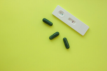 Negative pregnancy test and pills on a yellow background. Motherhood, children, pregnancy, concept of birth control. Health problems and problems with conception. abortion. contraception. Copy space.