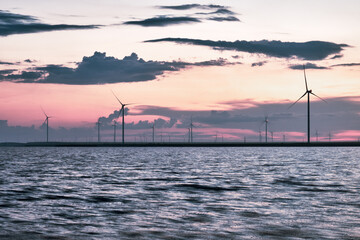Wind farms near the lake at sunset.