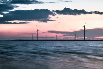 Wind farms near the lake at sunset.
