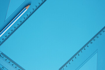 A picture of pencil with set square on copyspace  on blue background. Mathematics and engineering concept