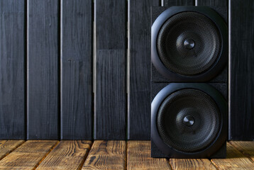 Frontal view of a two-way speaker system in an eco-friendly interior. Background from natural...