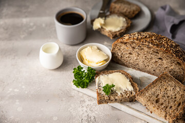 Freshly baked artisan multigrain bread with butter and pate. Breakfast with coffee, sliced bread, butter and liver pate.