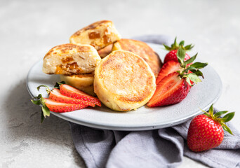 Cottage cheese pancakes or fritters with strawberry and natural yogurt. Healthy breakfast or lunch. Syrniki.