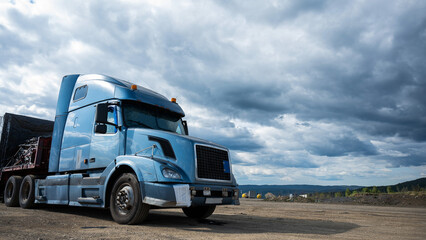 Fototapeta na wymiar A parked truck with a blue cab against a gray sky
