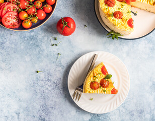 Piece of savoury tomato cheesecake with herbs decorated mint, blue concrete background. Top view.