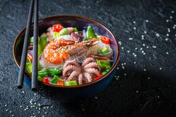 Spicy seafood noodle with octopus and shrimps. Asian cuisine.