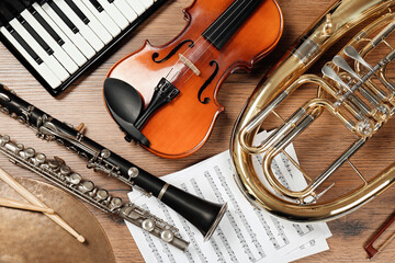 Set of different musical instruments on wooden background, flat lay