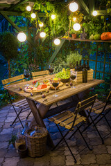 Garden table with wine and appetizers Evening garden meeting.