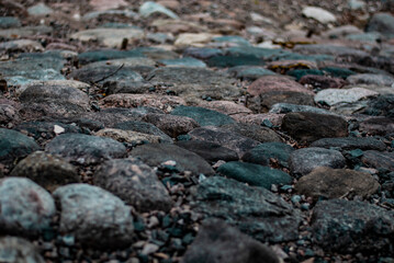 Large rounded stones on the road look like a pavement with small stones between the stones