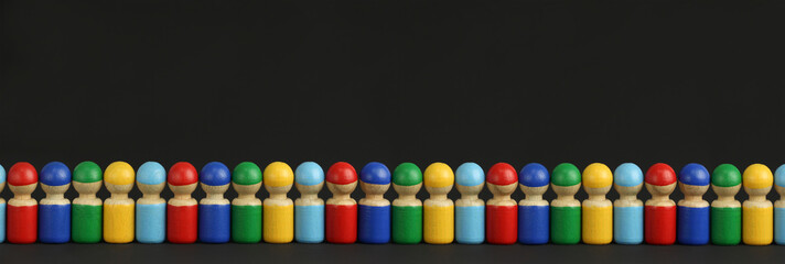 colorful wooden toy people are lined up in a row or queue, black background with copy space