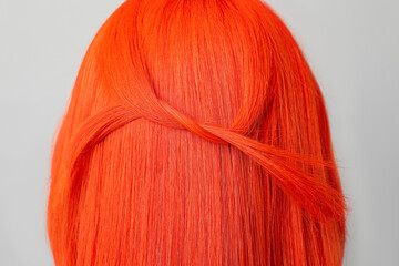 Young woman with bright dyed hair on grey background, closeup. Back view