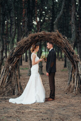 Fototapeta na wymiar walk of the bride and groom through the autumn forest