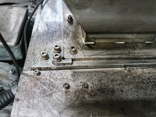 Group of Socket Head Screws Fastened on Dirty Machine Base