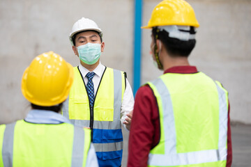 factory worker wearing medical face mask and talking about work with colleague