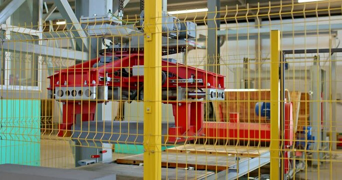 Modern automated elevator folds ready-made concrete products. Robotic stacker lift on the production line of a plant for the production of concrete road curbs. 4k, ProRes