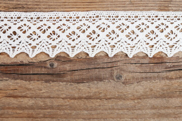 Traditional lace on rough wooden background, copy space.