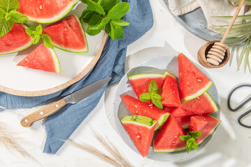 Composition of ripe watermelon and fresh mint on the kitchen table. Ripe summer watermelon. Juicy watermelon. Concept of seasonal fruits on the table