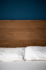 Fototapeta na wymiar Cabecero de cama de madera sobre fondo azul