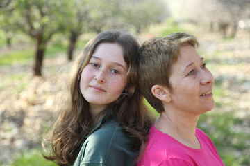 Fototapeta premium portrait of mom and teenage daughter outdoors