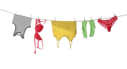 Clean clothes hanging on laundry line against white background