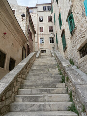 Fototapeta na wymiar Steep stone stairs and historic tenement houses in the old town of Sibenik