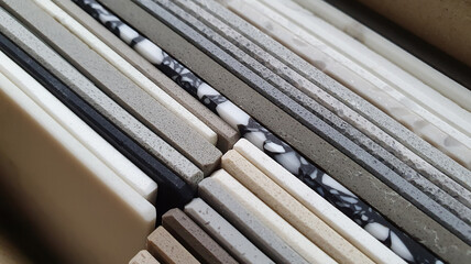 close up view of artificial stone samples in catalog box showing multi texture, color and pattern of samples. suitcase with samples of artificial stone in mcro view. interior finishing  material.