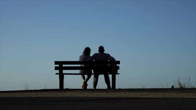Couple sitting on a park bench during the day in Cape Town, South Africa