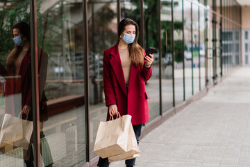 Close up portrait of a caucasian female wearing a medical mask and standing in the street and cafe