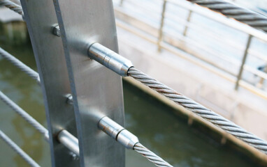 Stainless steel threaded stud joint with wire rope cable railing.