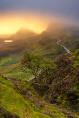 Dramatic view of magical Scotland landscape Quiraing  with lingering morning mist covering mountain...