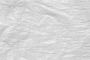 The texture of an uneven crumpled artificial fabric. Abstract white background for wallpaper, design