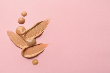 Samples of liquid skin foundation on pink background, top view. Space for text