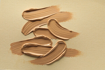 Sample of liquid skin foundation on beige background, top view
