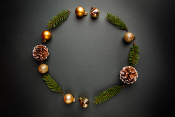 Christmas round frame made of winter decorations on black background. Christmas concept. Flat lay, top view.