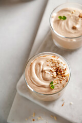 мmousse dessert with nutella, chocolate paste, cheese and cream with nuts on the table and on the board