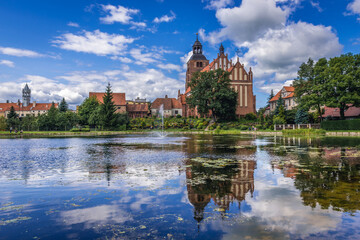 Pond and St Anne and St Stephen Roman Catholic gothic church in Barczewo town, Poland - obrazy, fototapety, plakaty