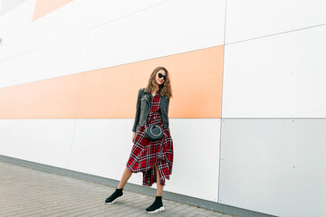 Urban fashionable girl hipster in dark sunglasses in fashion youth red-black dress in leather...